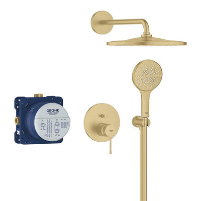 GROHE Essence concealed shower system in Brushed Gold laid out as a set: round rain head on its wall arm, hand shower on the outlet elbow, circular single-lever trim plate and the blue Rapido SmartBox rough-in valve