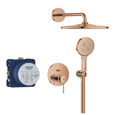 GROHE Essence concealed shower system in Bronze with the Rainshower Mono 310 head: round wall flange and arm, round trim plate with single lever and diverter button, round hand shower on its holder, shown alongside the blue GROHE concealed rough-in body