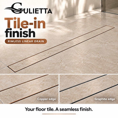 Gulietta Base rimless linear shower drain with matching beige floor tile inserted into the reversible cover, showing copper and graphite edges; illustrative installation